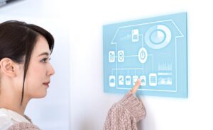 美しいアジア人女性がスマートハウスのパネルを操作する画像