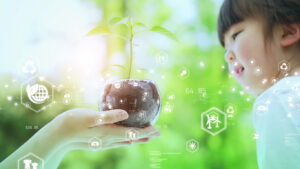 木が植えられているガラスの鉢を両手で持つ。それを楽しそうにみる小さな女の子の画像