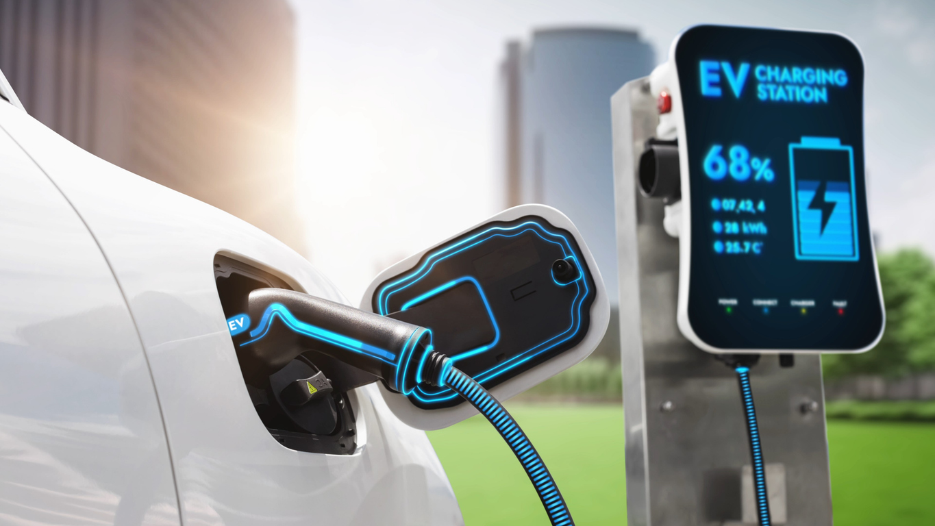 屋外で電気自動車が充電ステーションに接続されている様子。充電器のコネクタとケーブルが青い光で強調表示されており、充電ステーションの画面には「EV CHARGING STATION」と表示され、充電の進捗状況が68%と示されている画像